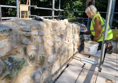 Lauren using hot mixed lime mortar to consolidate the chalk ruins at Ankerwycke Priory.