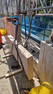Stone being lifted using straps
