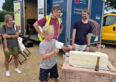 Child being taught letter cutting by stonemasons