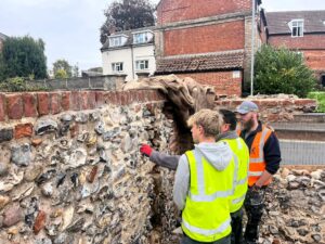 Group of workers looking at a flint wall