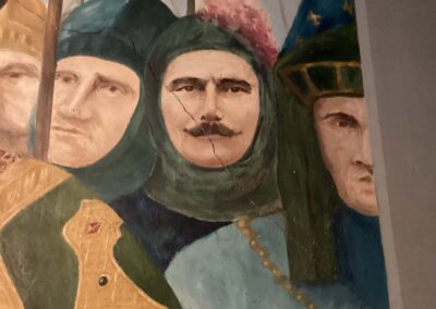 Fine diagonal crack running across the painted plaster surface of the Burghers of Calais mural, before conservation intervention.