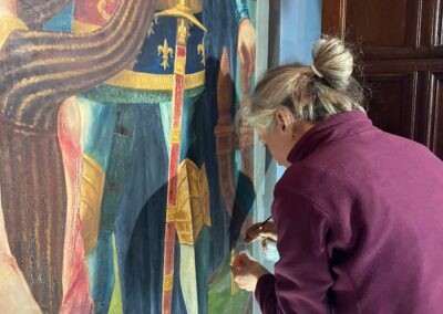 A Cliveden Conservation conservator carrying out work on the Burghers of Calais wall painting at Plumpton House.