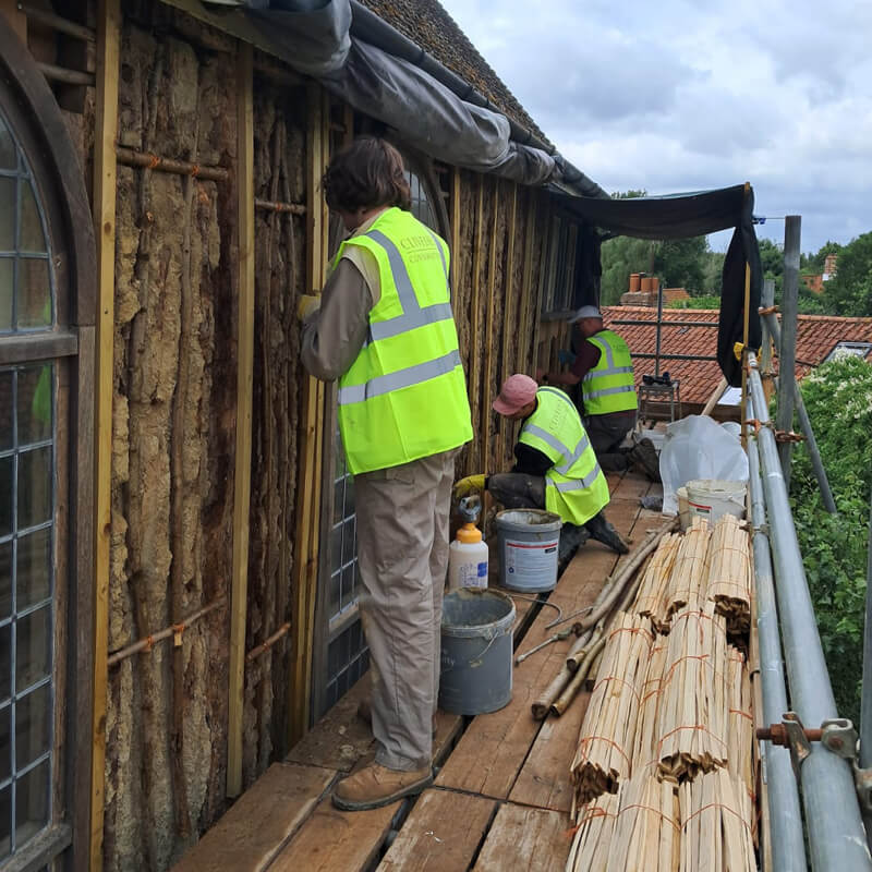 Conservators working on the repair of a timber frame building, Walpole Chapel