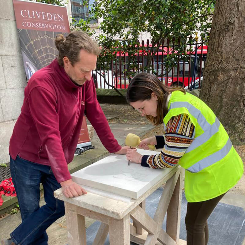 Young girl being taught how to do letter cutting by Cliveden Conservation tutor
